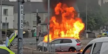 Dramatic footage shows crowds gather as car erupts into ’30ft’ flames