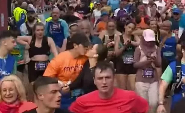 The adorable moment a man and a woman high five and kiss at the finish line of the Cardiff Half Marathon