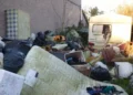 ‘Eyesore’ piles of rubbish and old caravan finally removed from Swansea garden
