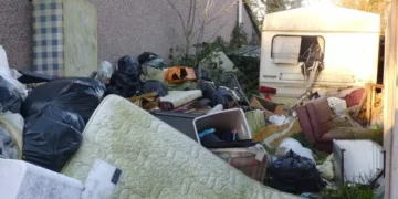 ‘Eyesore’ piles of rubbish and old caravan finally removed from Swansea garden